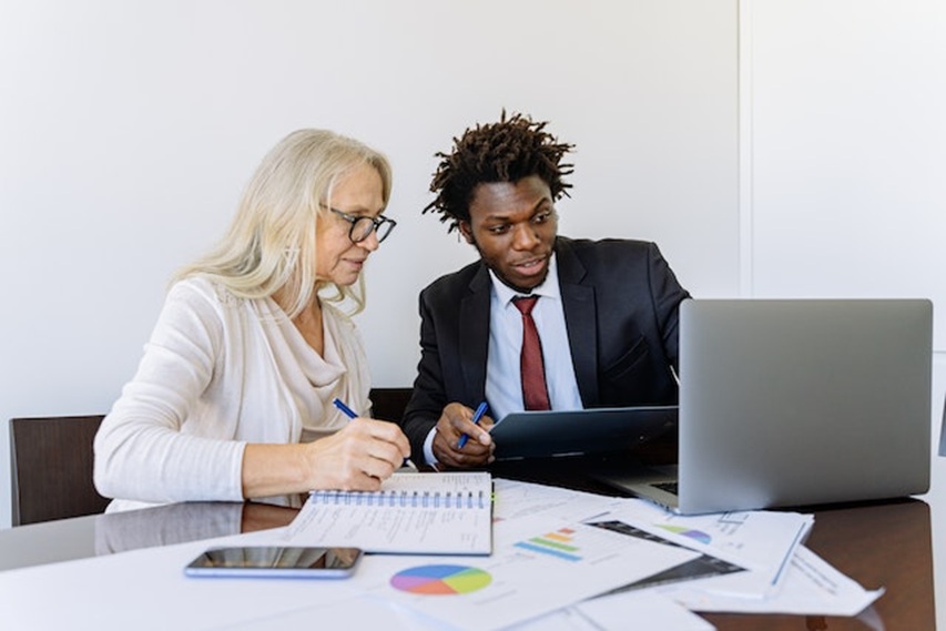 a property manager in a black suit going over stats with someone in a white shirt